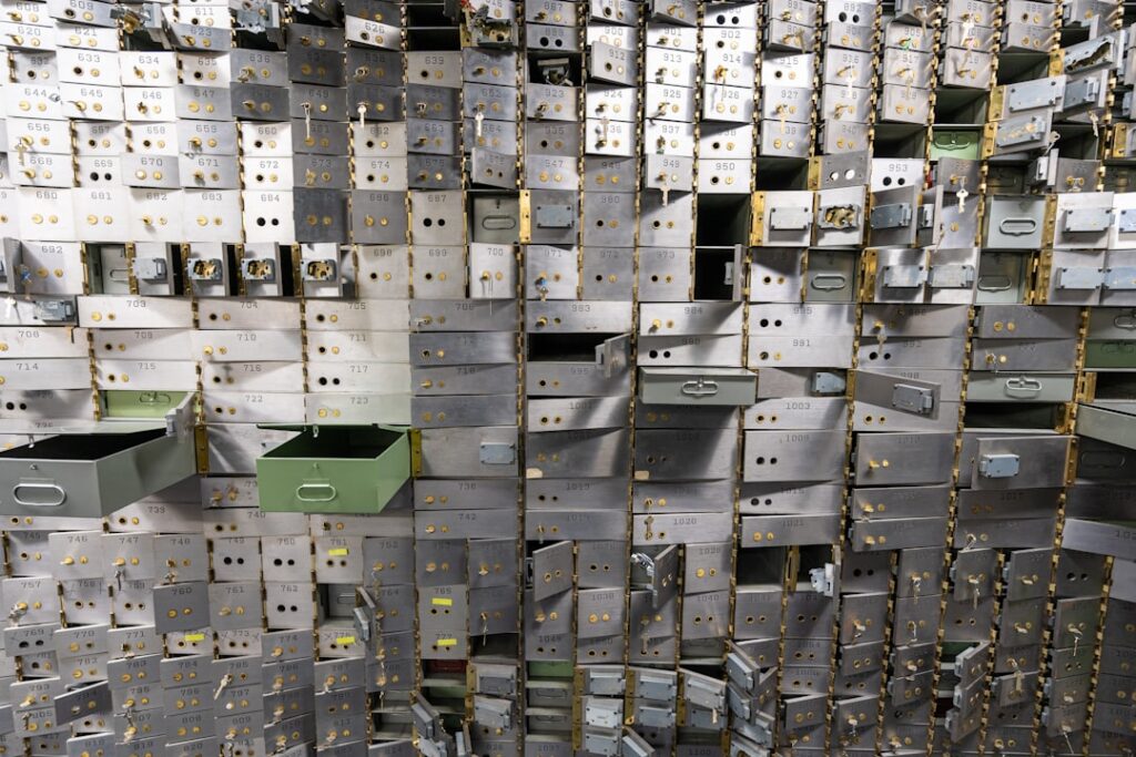 Rows of safe deposit boxes in a bank vault, representing how CDC holds shares in sub-accounts, Investor Accounts, and omnibus accounts
